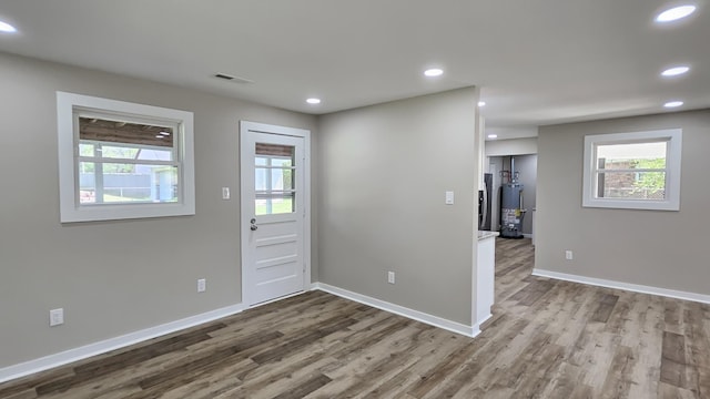 foyer featuring water heater, baseboards, recessed lighting, visible vents, and wood finished floors