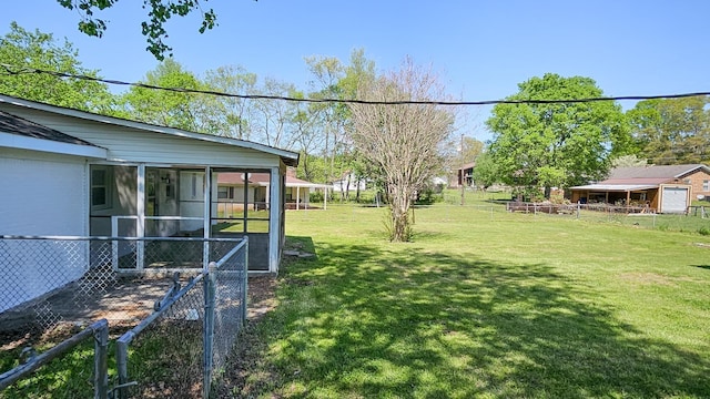view of yard featuring fence and a sunroom
