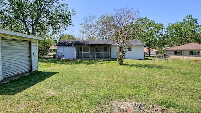 back of property featuring a yard and fence