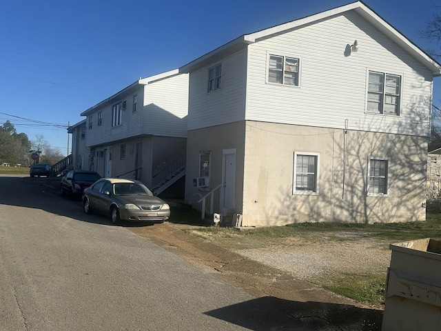 - view of side of home with stairs and cooling unit