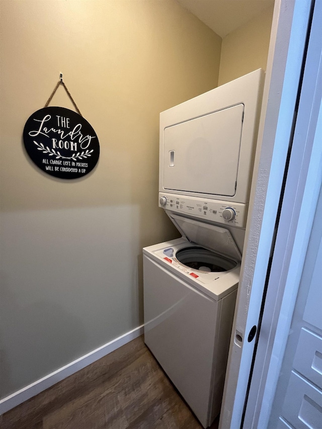 laundry room with dark hardwood / wood-style flooring and stacked washer / dryer