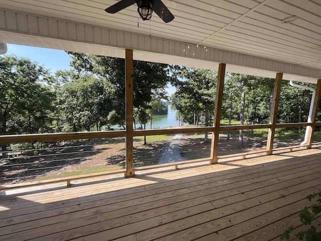 wooden terrace with a water view and ceiling fan