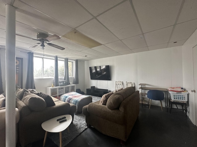  - living area with ceiling fan and a drop ceiling
