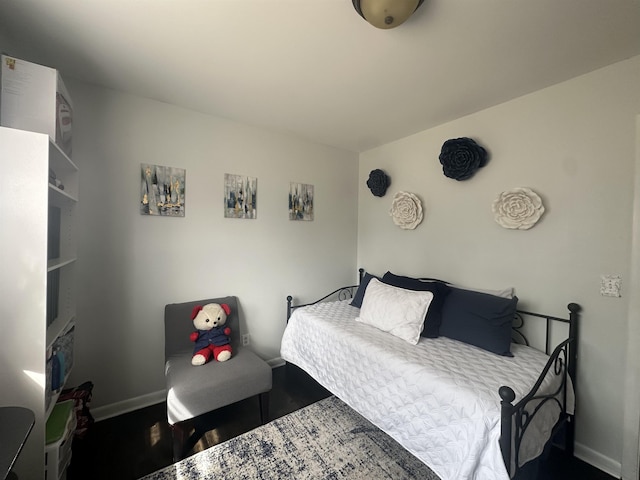  - bedroom featuring baseboards and wood finished floors