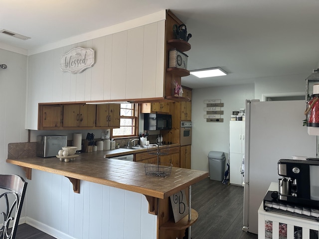 kitchen featuring wall oven, visible vents, dark wood-type flooring, black microwave, and open shelves