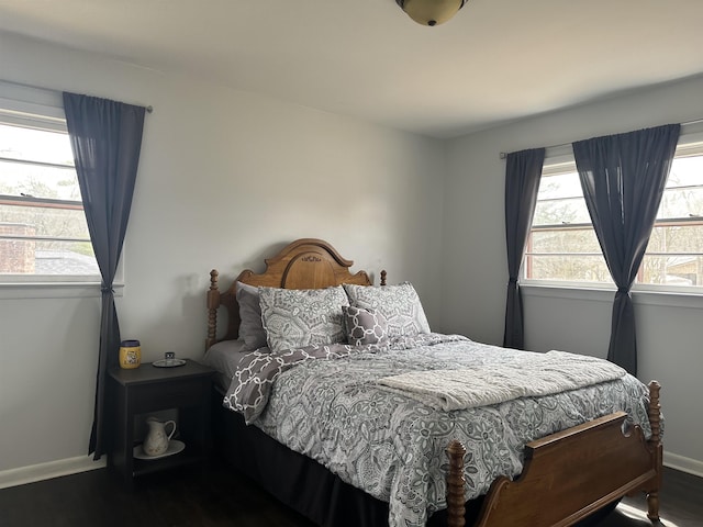  - bedroom featuring multiple windows, baseboards, and wood finished floors