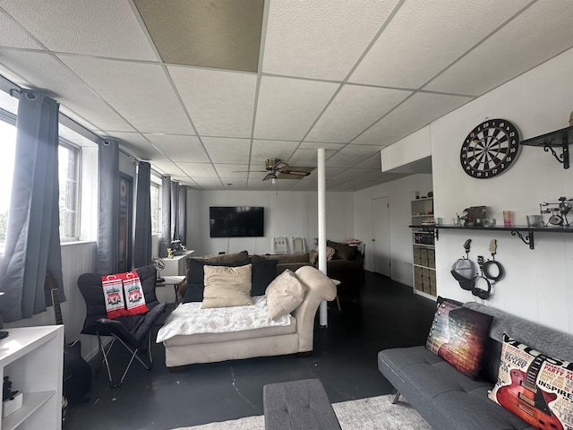  - living area featuring a paneled ceiling, a ceiling fan, and concrete floors