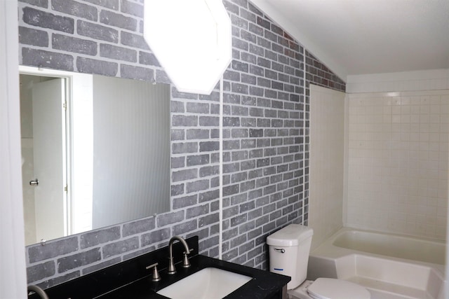 full bathroom with vanity, lofted ceiling, tiled shower / bath, and toilet