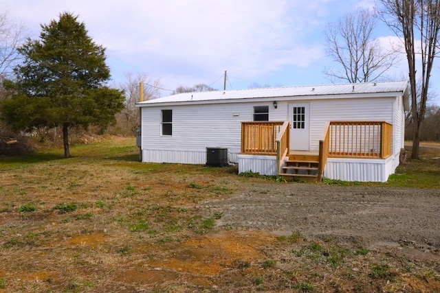 rear view of property featuring a wooden deck and central AC