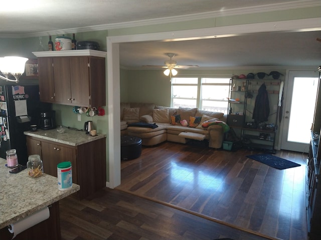 kitchen featuring dark hardwood / wood-style floors, ceiling fan, black refrigerator, and crown molding