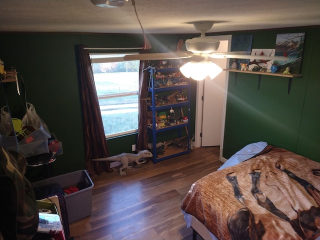 bedroom with wood-type flooring, a textured ceiling, and ceiling fan