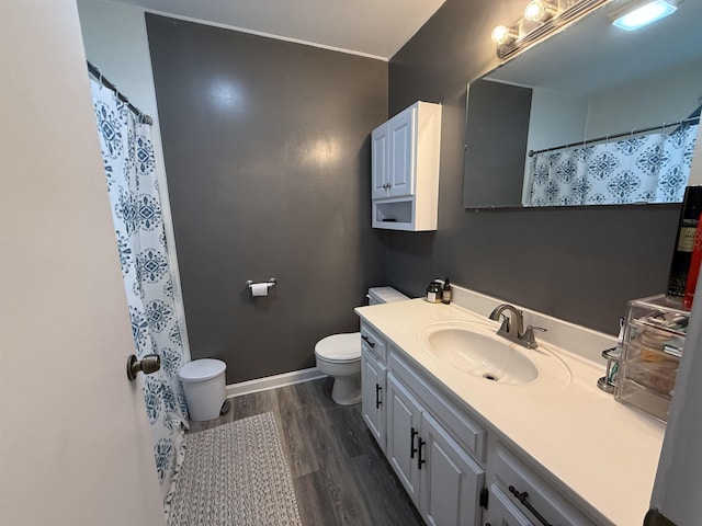  - bathroom featuring toilet, wood finished floors, vanity, baseboards, and curtained shower