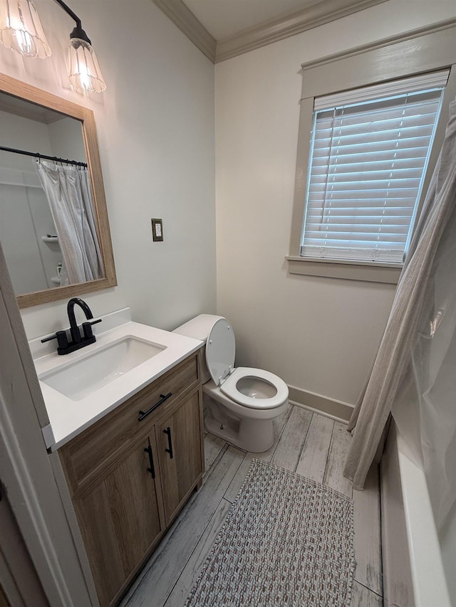  - full bath with crown molding, wood finished floors, vanity, toilet, and baseboards