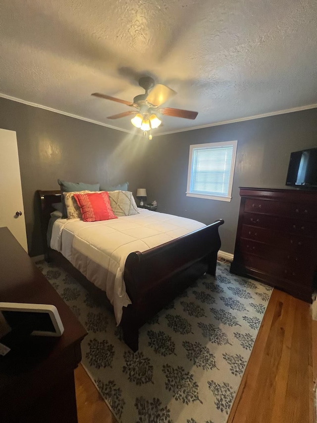  - bedroom with ornamental molding, a textured ceiling, wood finished floors, and ceiling fan