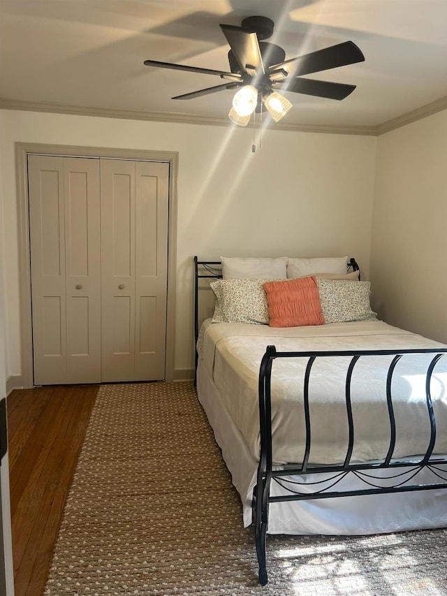  - bedroom with crown molding, wood finished floors, a closet, and ceiling fan