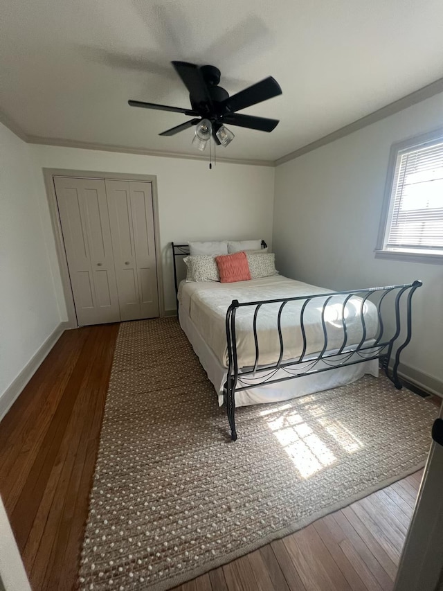  - bedroom featuring hardwood / wood-style floors, a closet, baseboards, and ornamental molding