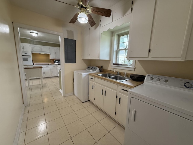  - washroom featuring cabinet space, electric panel, light tile patterned flooring, washer and clothes dryer, and baseboards