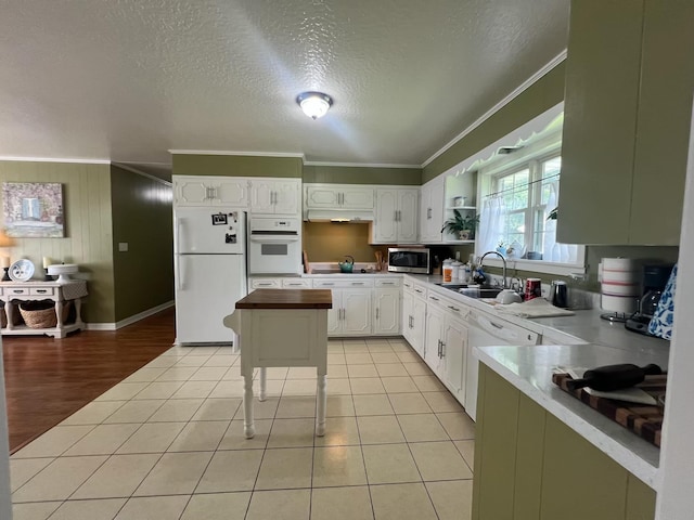  - kitchen featuring white appliances, crown molding, a sink, white cabinetry, and a textured ceiling