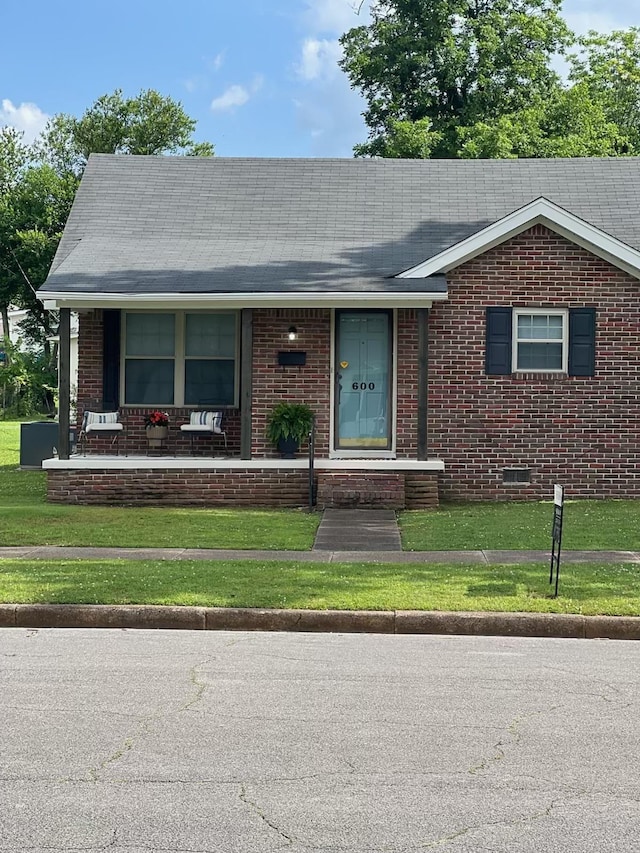  - view of front of home featuring brick siding, a front yard, and crawl space
