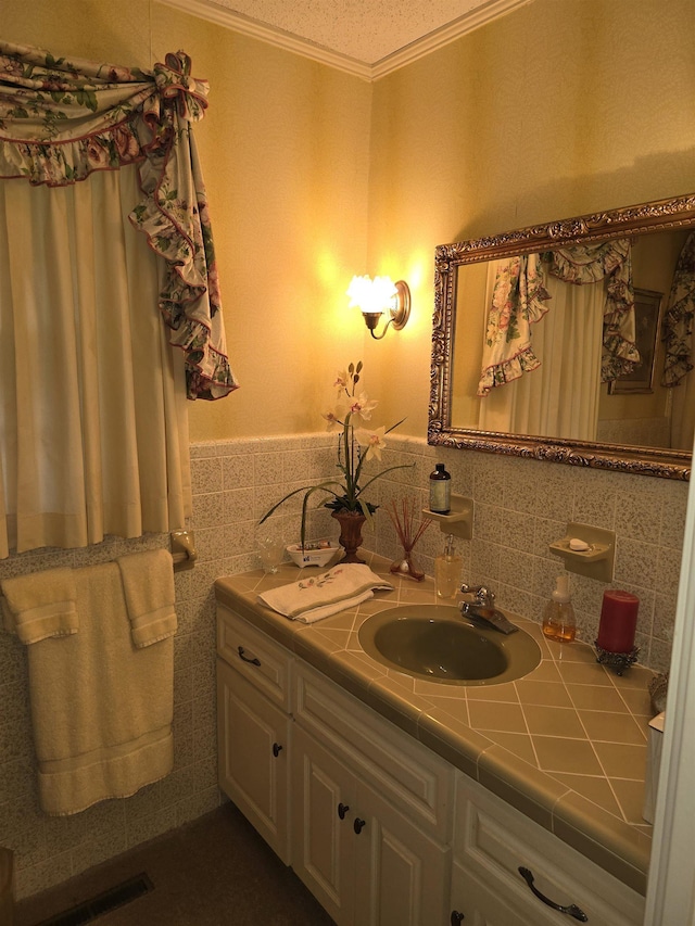 bathroom featuring crown molding, vanity, and a textured ceiling