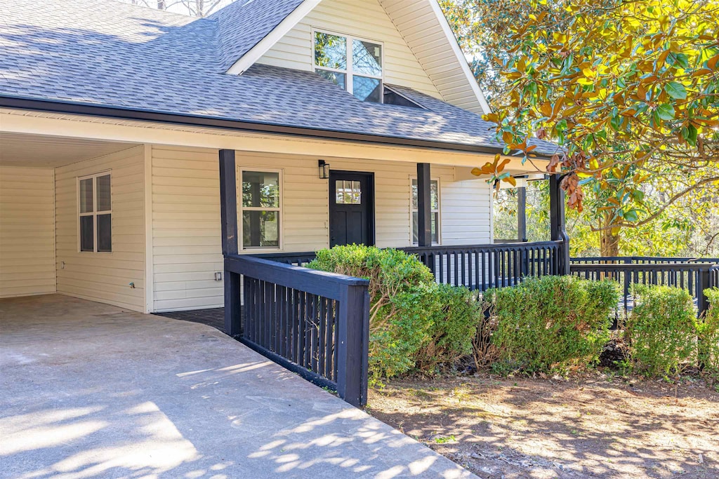 doorway to property featuring covered porch and a carport