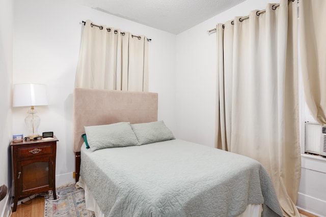  - bedroom featuring light wood-type flooring and a textured ceiling