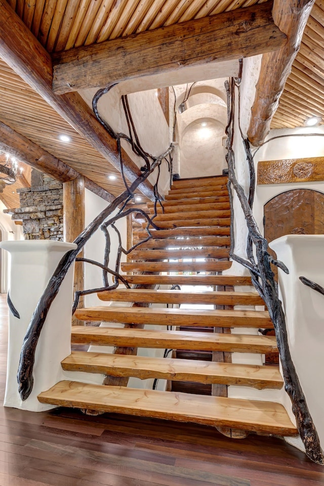 stairway featuring beamed ceiling, hardwood / wood-style floors, and wooden ceiling