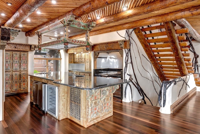 kitchen with a kitchen island with sink, dark wood-type flooring, beamed ceiling, wood ceiling, and a sink