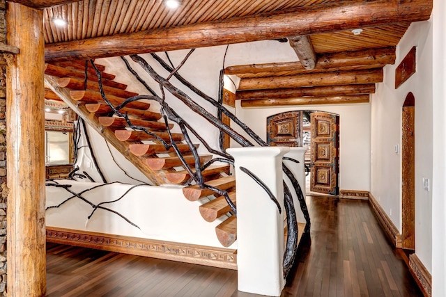 stairs with hardwood / wood-style floors, arched walkways, beam ceiling, and wooden ceiling