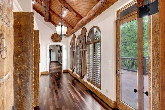 hallway featuring arched walkways, wood ceiling, a wealth of natural light, and wood-type flooring
