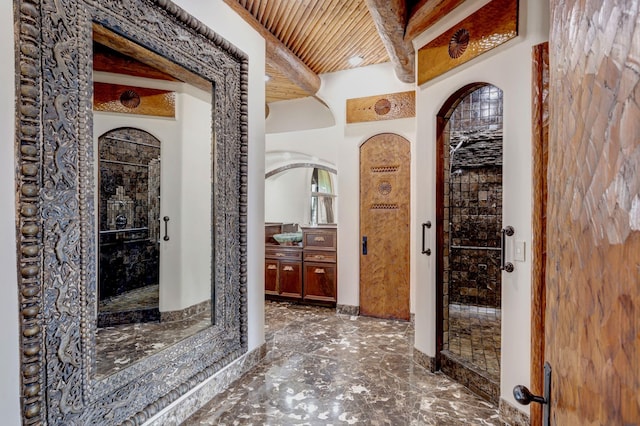 interior space with beamed ceiling, wood ceiling, a stall shower, and vanity