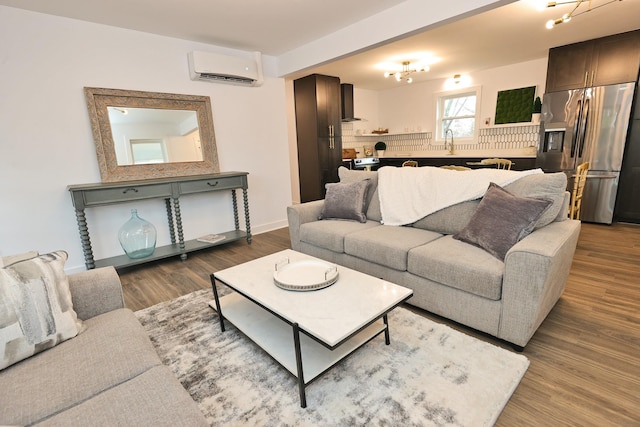 living room featuring a wall mounted air conditioner, hardwood / wood-style floors, and sink