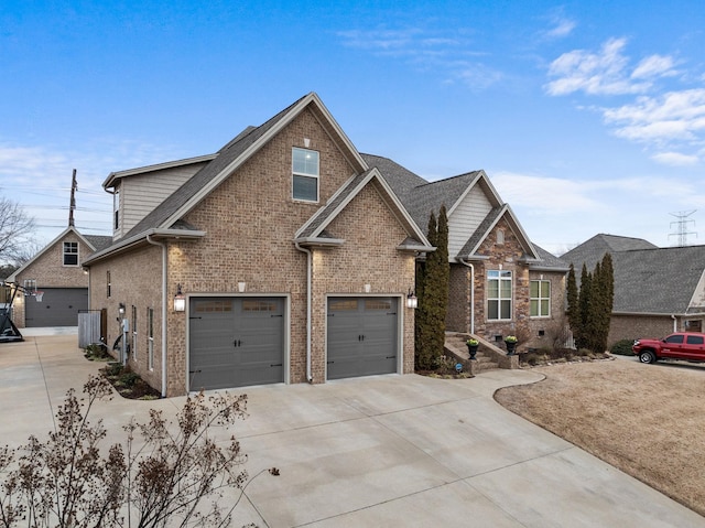 craftsman-style house with brick siding, an attached garage, driveway, and roof with shingles