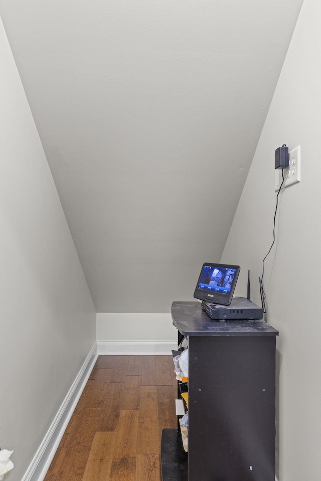 home office with dark wood finished floors, baseboards, and vaulted ceiling