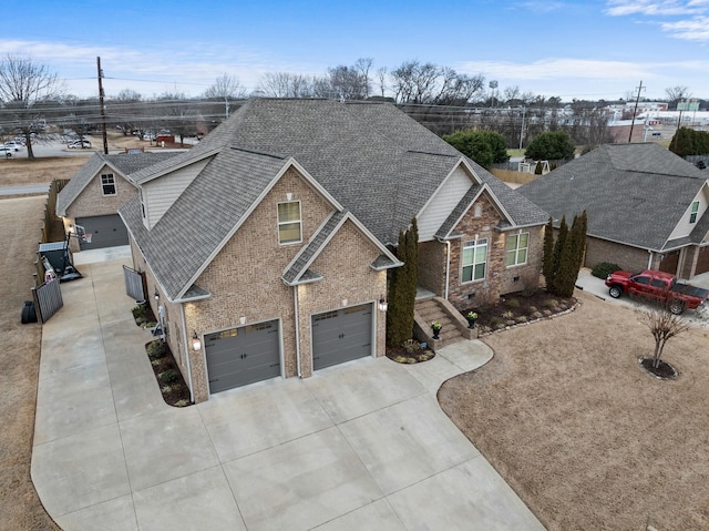 view of front of home with brick siding, concrete driveway, a shingled roof, and a garage