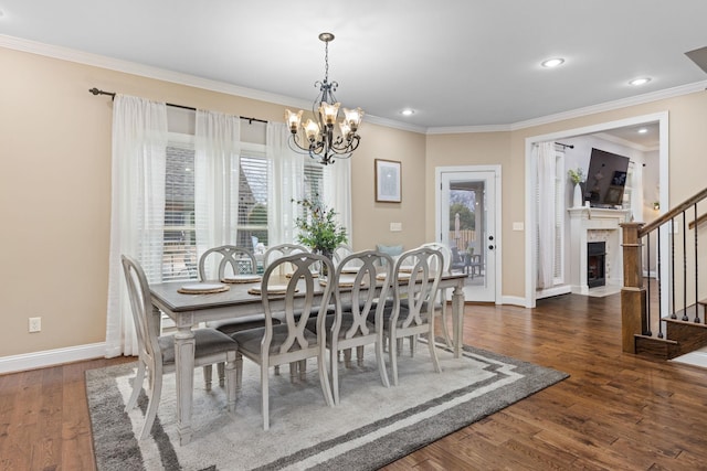 dining area featuring a fireplace with flush hearth, dark wood-type flooring, an inviting chandelier, crown molding, and baseboards