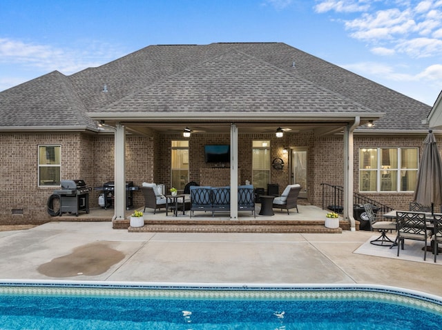 pool with a patio area, a grill, and an outdoor hangout area