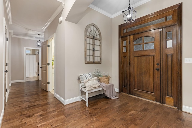 entryway featuring crown molding, dark wood-type flooring, and a chandelier