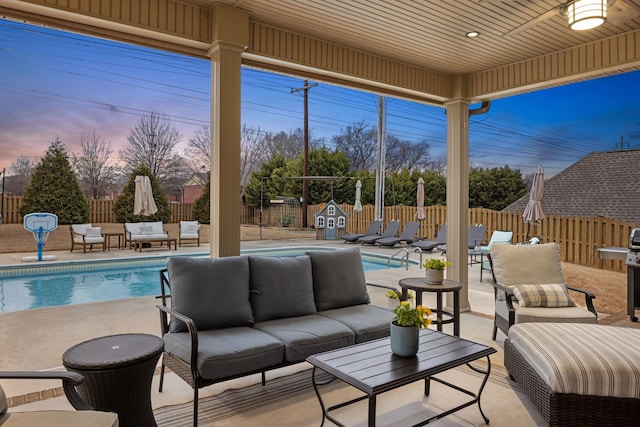 patio terrace at dusk with an outdoor living space, a fenced backyard, and a fenced in pool