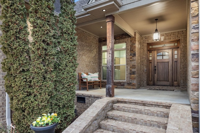 property entrance featuring brick siding and covered porch