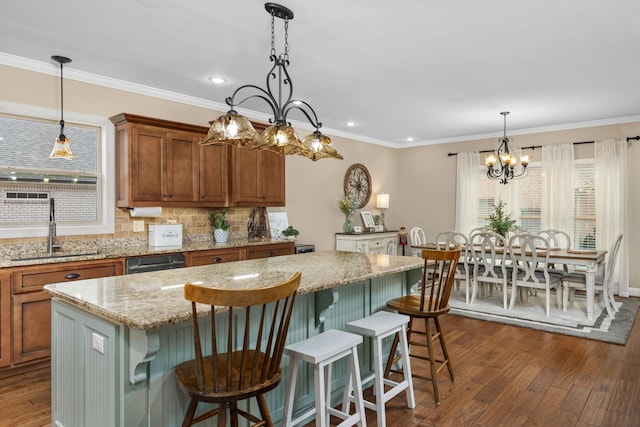 kitchen featuring dark wood-style floors, plenty of natural light, brown cabinetry, and a sink