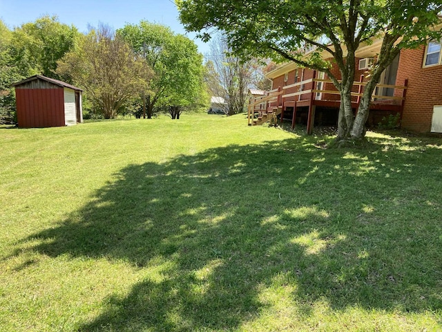 view of yard with a deck, a shed, and an outbuilding