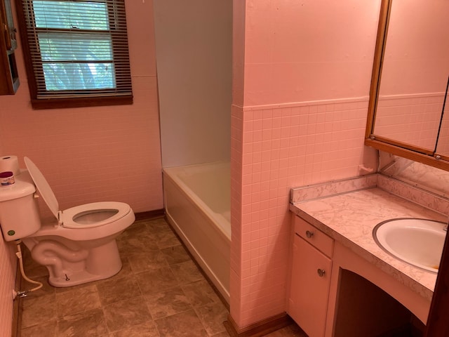 full bath featuring toilet, tile walls, and vanity