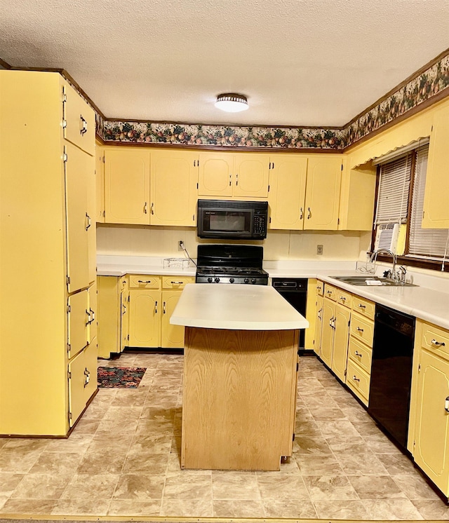 kitchen with a sink, black appliances, light countertops, and a center island