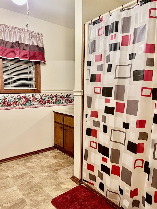 bathroom featuring baseboards, vanity, and a shower with curtain