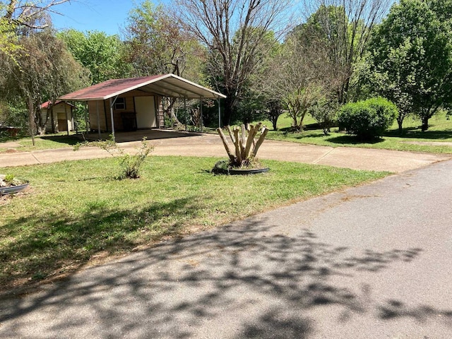 view of property's community with a lawn, driveway, and a detached carport