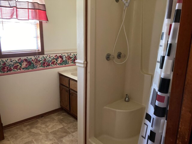 full bathroom featuring a shower stall, vanity, and baseboards