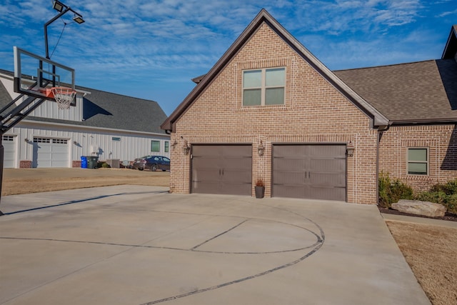 view of front facade with an attached garage, brick siding, driveway, and a shingled roof