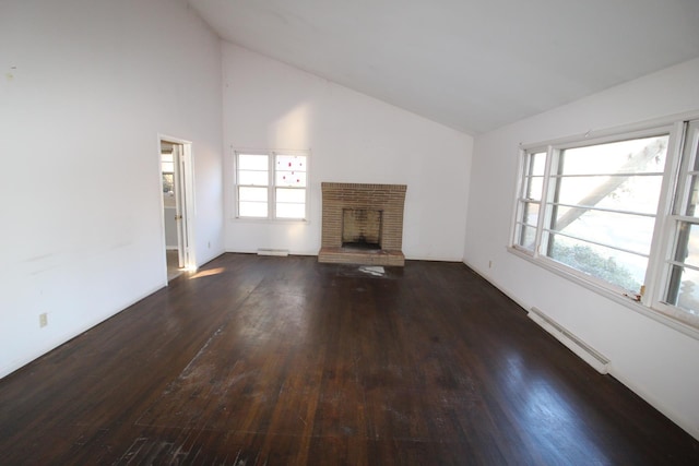  - unfurnished living room featuring a baseboard radiator, lofted ceiling, hardwood / wood-style flooring, plenty of natural light, and a brick fireplace