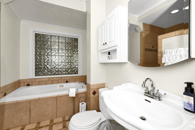 bathroom featuring crown molding, toilet, sink, and tiled tub